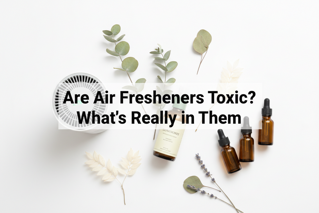  Flat lay of non-toxic home fragrance products including a LEVOIT air purifier, room spray bottle, and amber essential oil bottles with eucalyptus and lavender sprigs on white background. Text reads: Are Air Fresheners Toxic? What's Really in Them.
