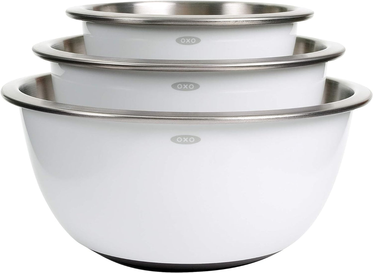 Set of three white mixing bowls with stainless steel rims and OXO branding on a white background