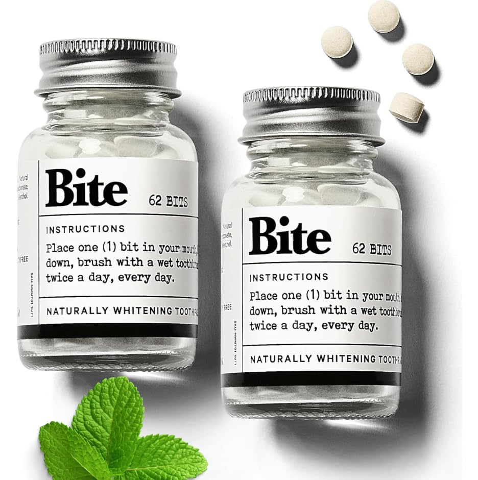 Two bottles of 'Bite' naturally whitening tooth product with mint leaves on a white background.