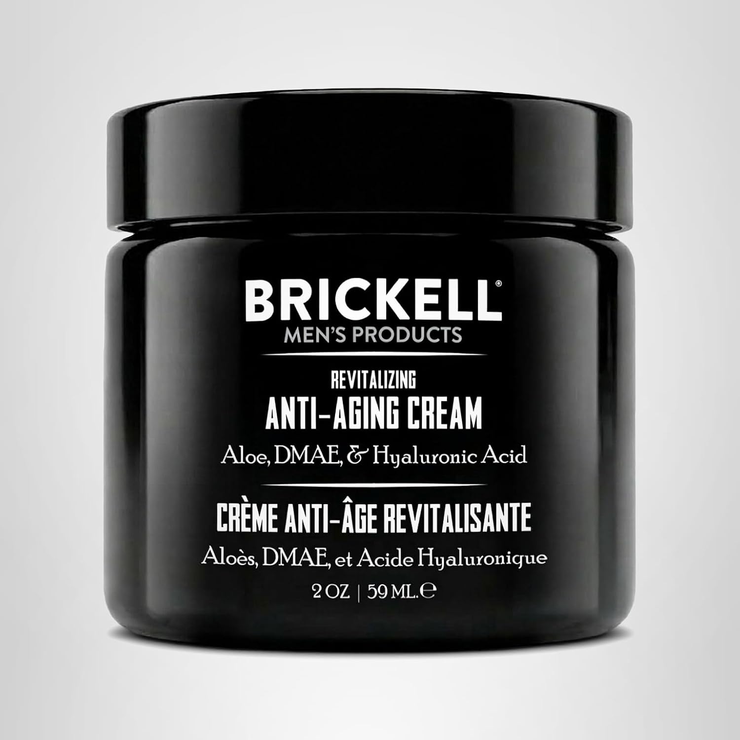 Black jar of Brickell Men's Products anti-aging cream on a light gray background