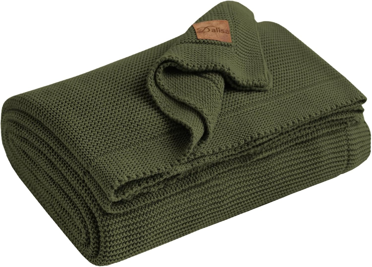 Folded olive-green knit throw blanket with textured stitching on a white background.