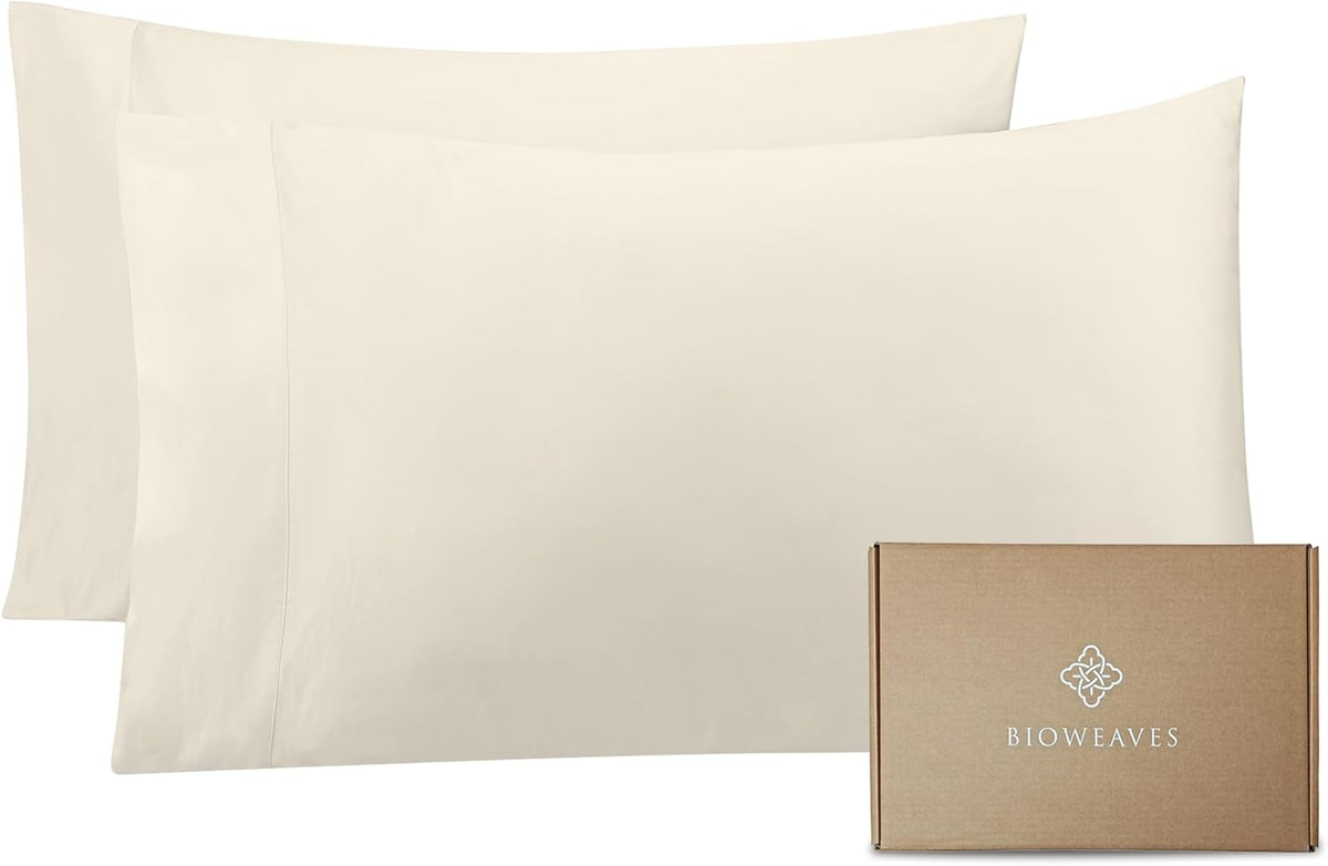 Two cream-colored BIOWEAVES pillowcases beside the brand’s brown packaging