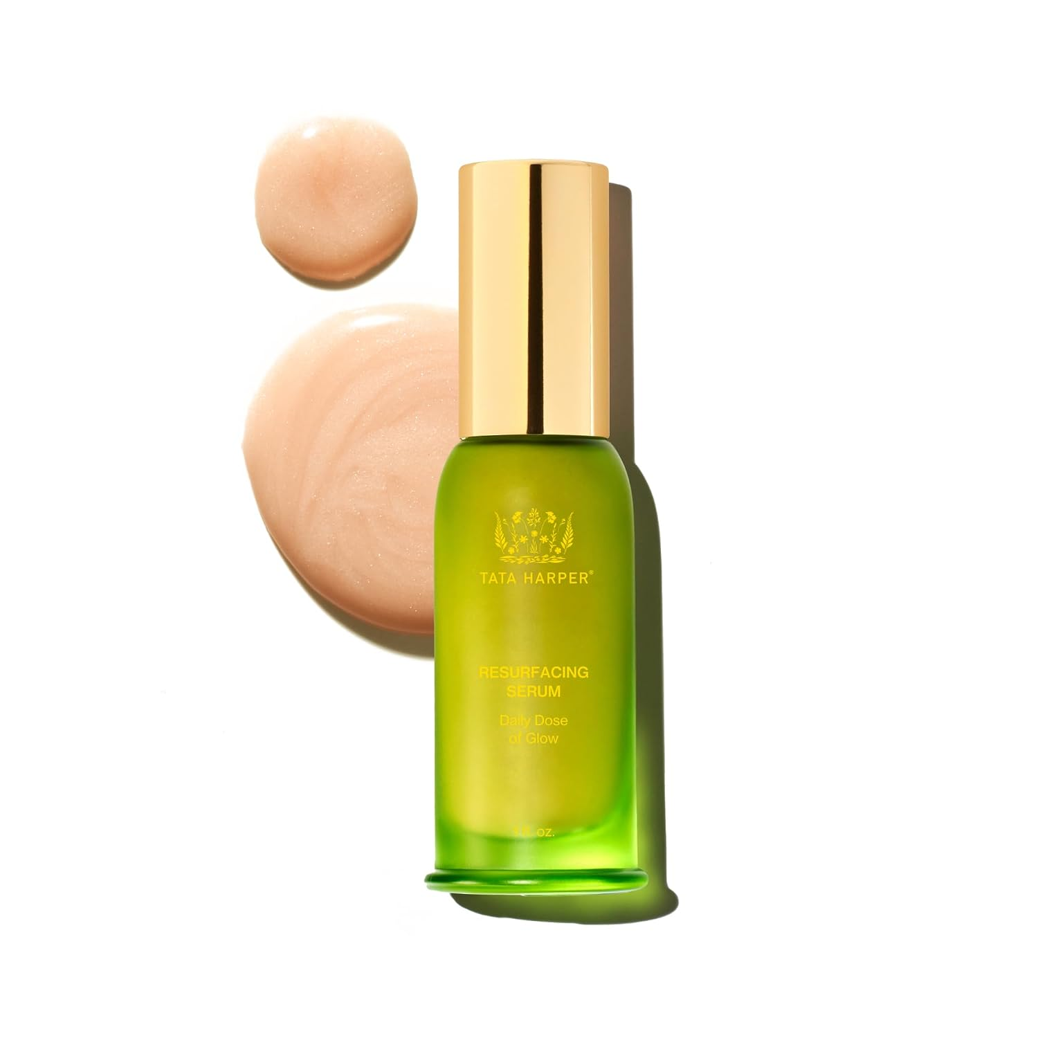 Tata Harper Resurfacing Serum in a vibrant green glass bottle with gold cap, shown with a peach-toned serum swatch on a white background