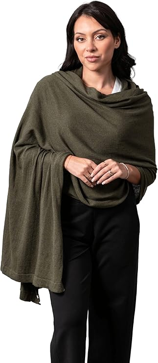 Woman wearing an olive-green Dreamsoft Travel Scarf draped as a wrap over a white top and black pants.