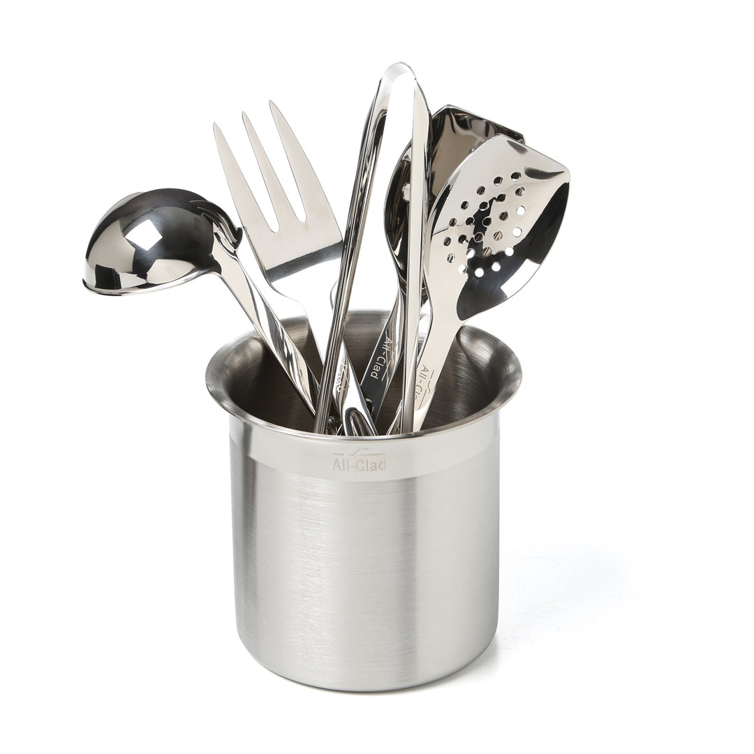 All-Clad stainless steel kitchen utensil set with ladle, spoons, turner, and matching storage caddy on a white background