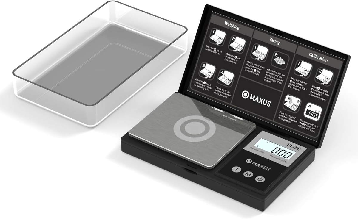 MAXUS digital pocket scale with weighing platform, clear cover tray and open instruction lid on a white background.