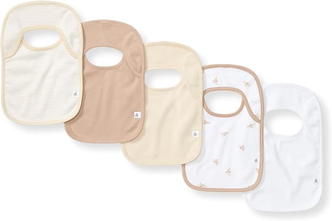 Five Burt's Bees Baby organic cotton bibs in neutral tones cream tan beige and white with tiny floral print fanned out flat lay on white background with absorbent terry towel backing and lap-shoulder design